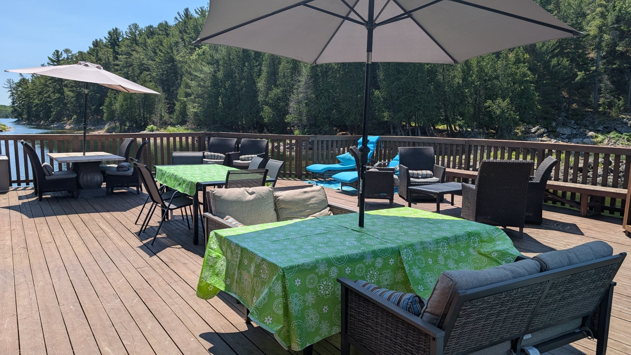 Spacious waterfront deck with outdoor dining and lounge seating